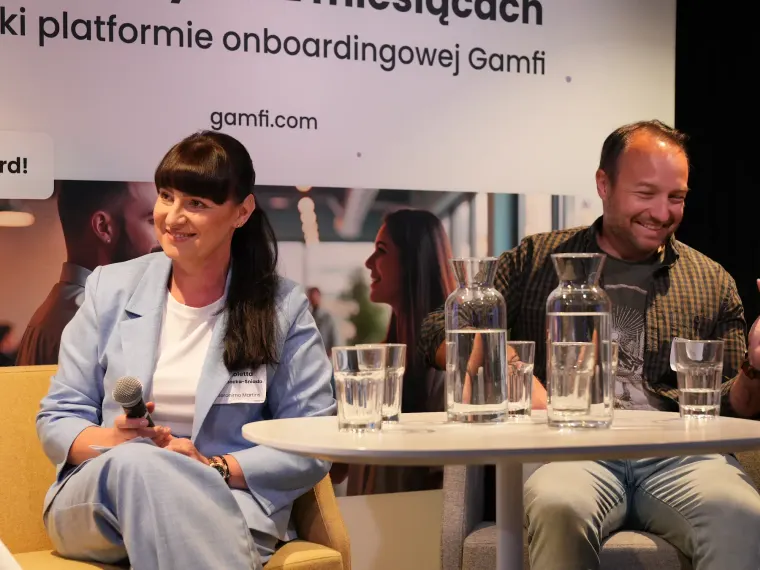 Troje panelistów przy stoliku na scenie